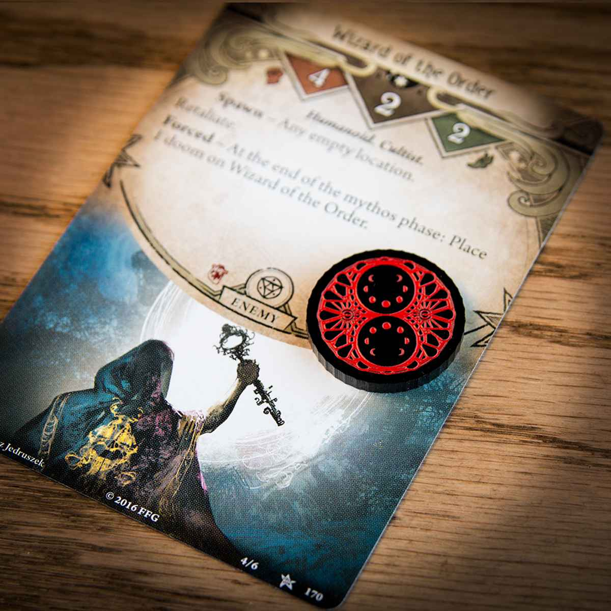 A two-value Doom token on top of the Arkham Horror LCG card "Wizard of the Order"