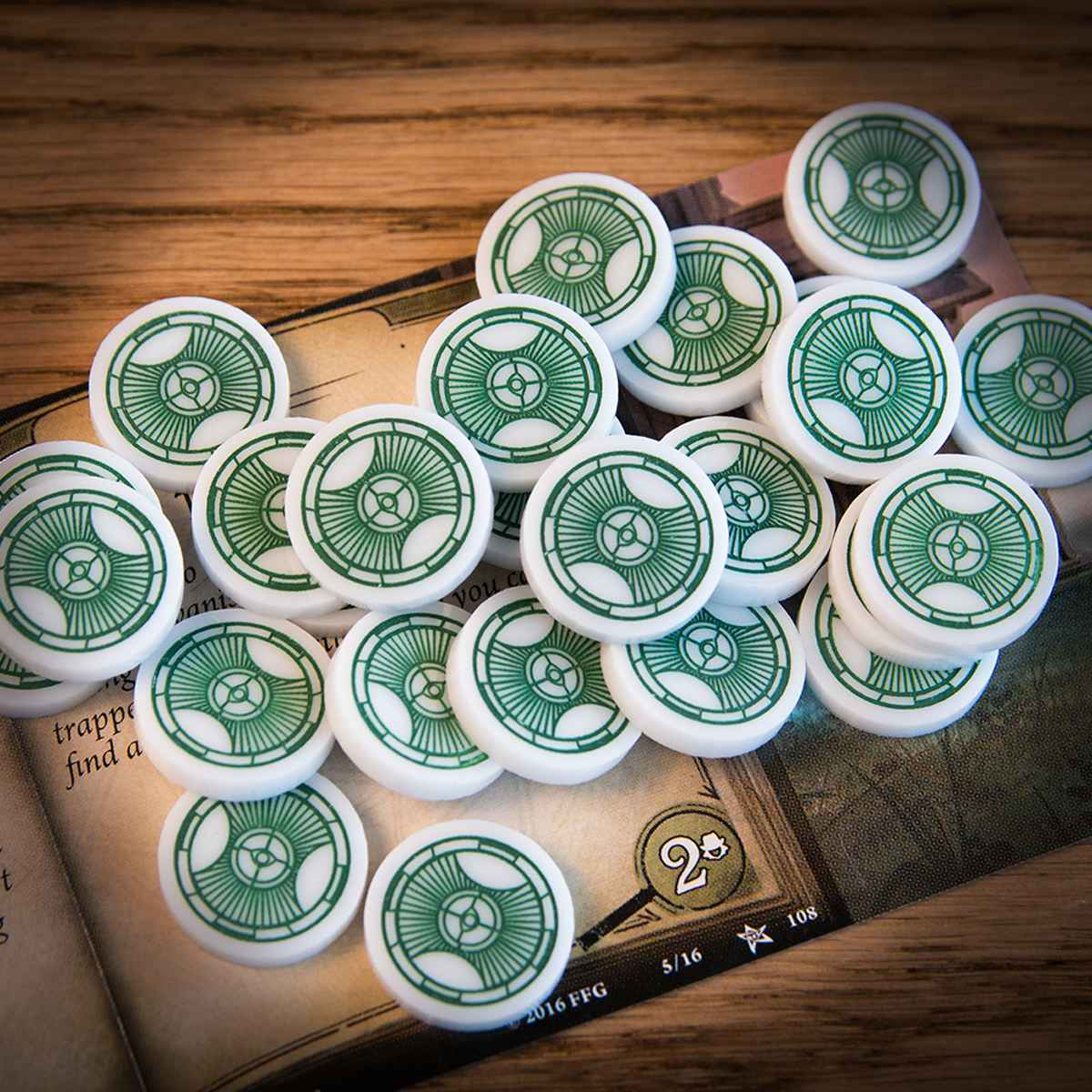 A pile of Resource Tokens on top of a Arkham Horror LCG Act card