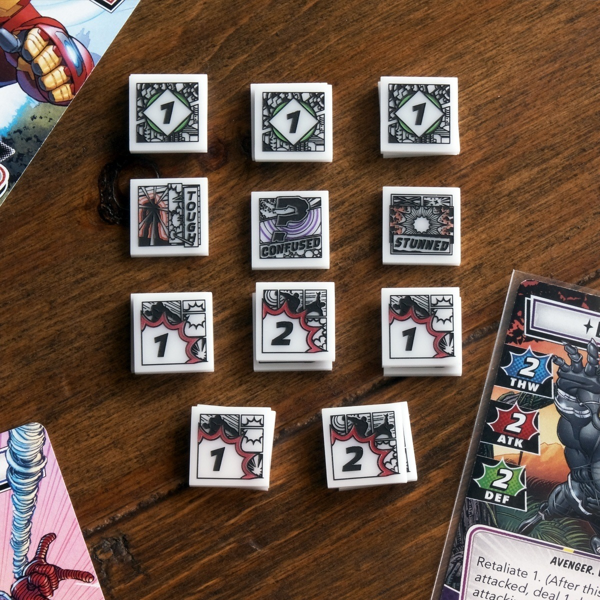 Full set of Hero Cosmic Tokens displayed on a wooden table and surrounded by cards from Marvel Champions LCG