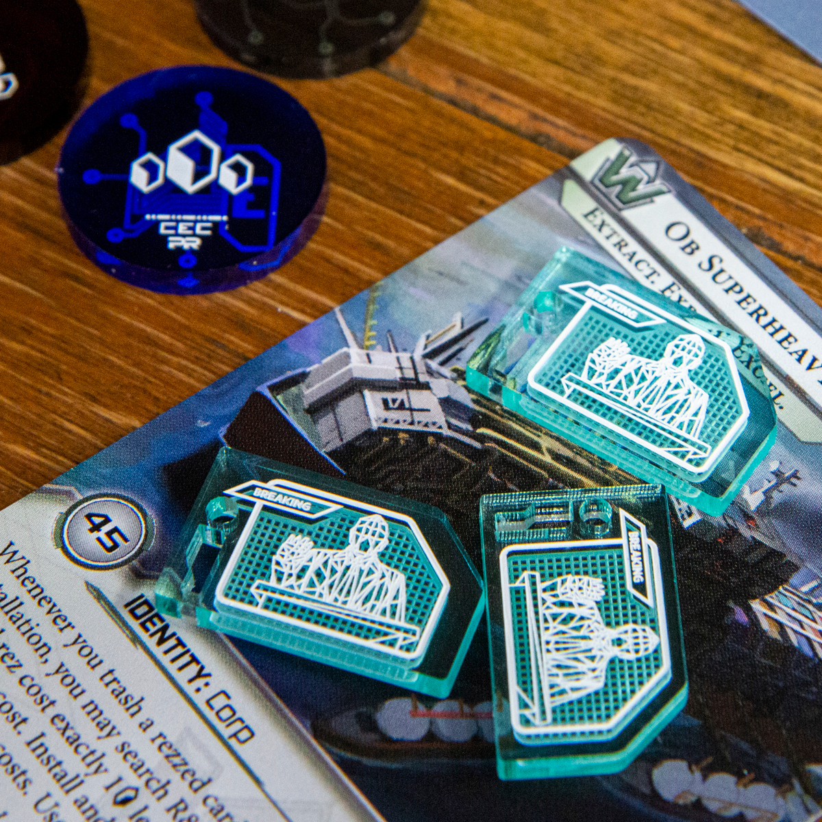 Three Bad Publicity tokens on top of the Netrunner identity Ob Superheavy Logistics, above the card there is a 3-value credit token