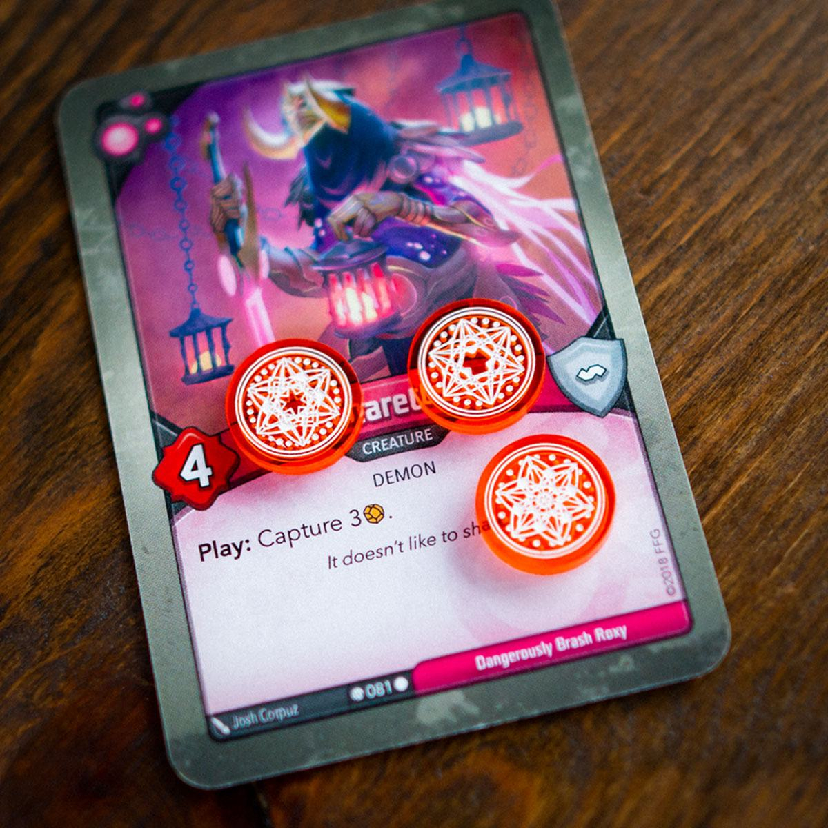 Unique Amber tokens of three different designs on top of the Keyforge card Charette