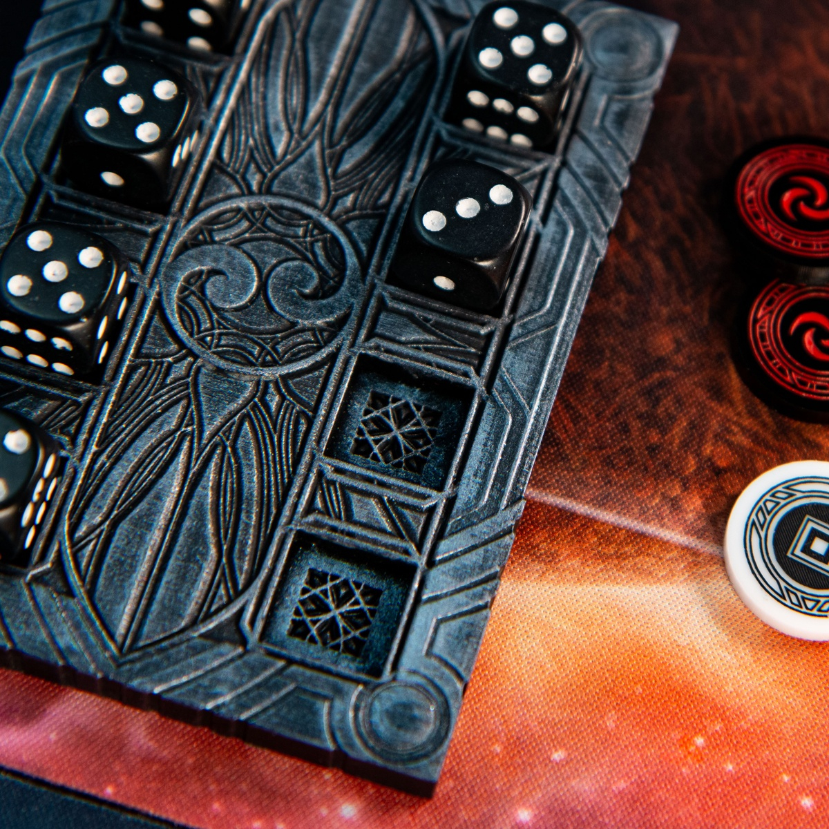 Close up of the detail in the Majestic Dice Board - Battleworn Edition's dice recesses with two Resource Tokens and an Activation Token from the Majestic Token set to the right