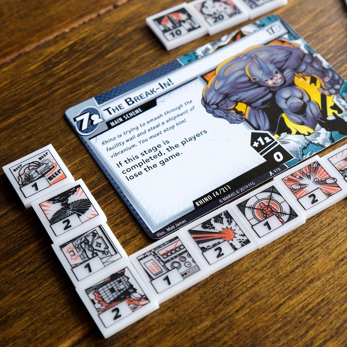 Rhino scheme card from Marvel Champions LCG surrounded by the threat tokens from the Villain Cosmic Token Set, highlighting the threat tokens' story-driven design