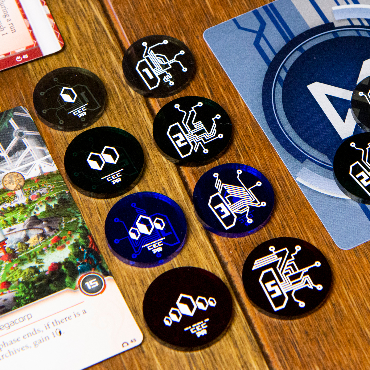 A lineup of credit tokens and their flip sides between two Null Signal Games Netrunner cards.