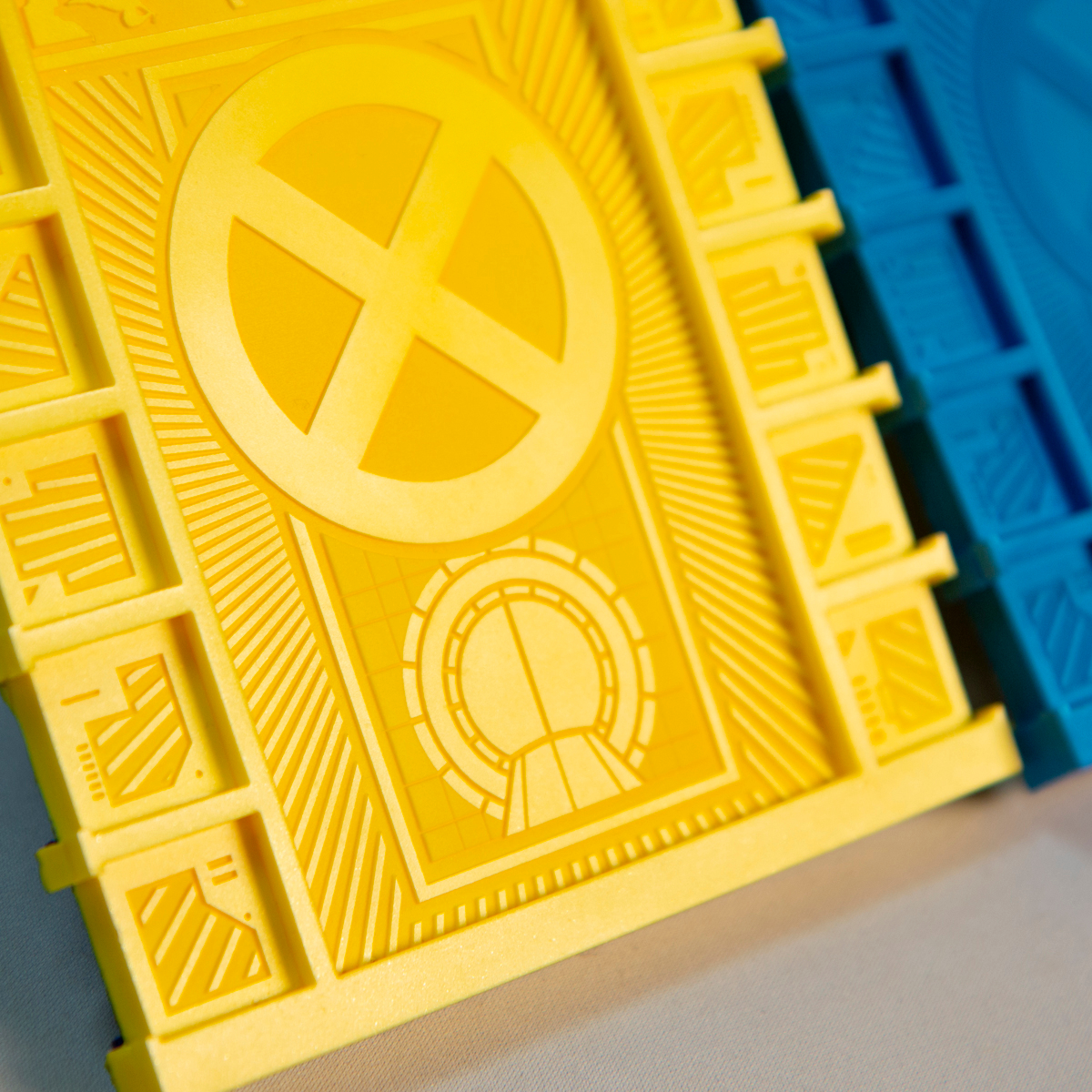 An angled shot of the Yellow Beam Cosmic Board showing the shining effect of the raised surfaces as well as a close up of the comic book inspired design