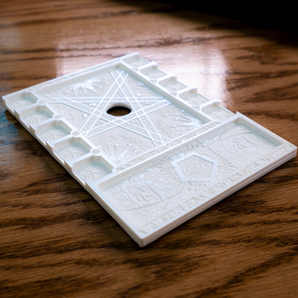 Dynamic angle of the Edge of Earth Mythos Board with the Clue/Resource holder in the right position, raised surfaces glowing radiant blue in the light.