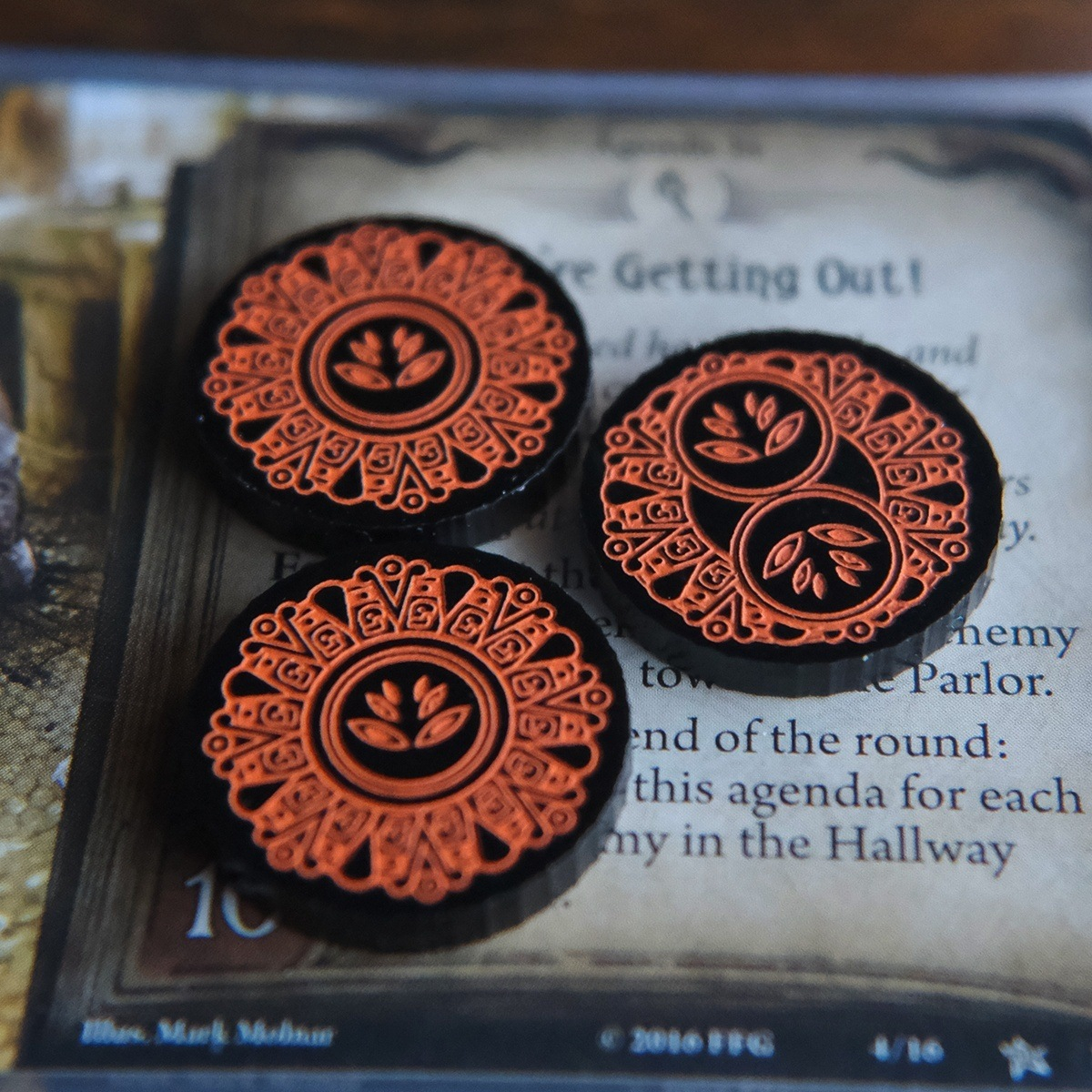 Two one-value and one two-value Forgotten Limited Edition Doom tokens on top of the Arkham Horror LCG Agenda, We’re Getting Out!