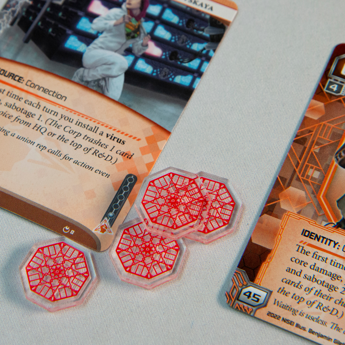 Three Virus Tokens from the Data Token set near two Anarch faction cards designed by Null Signal Games
