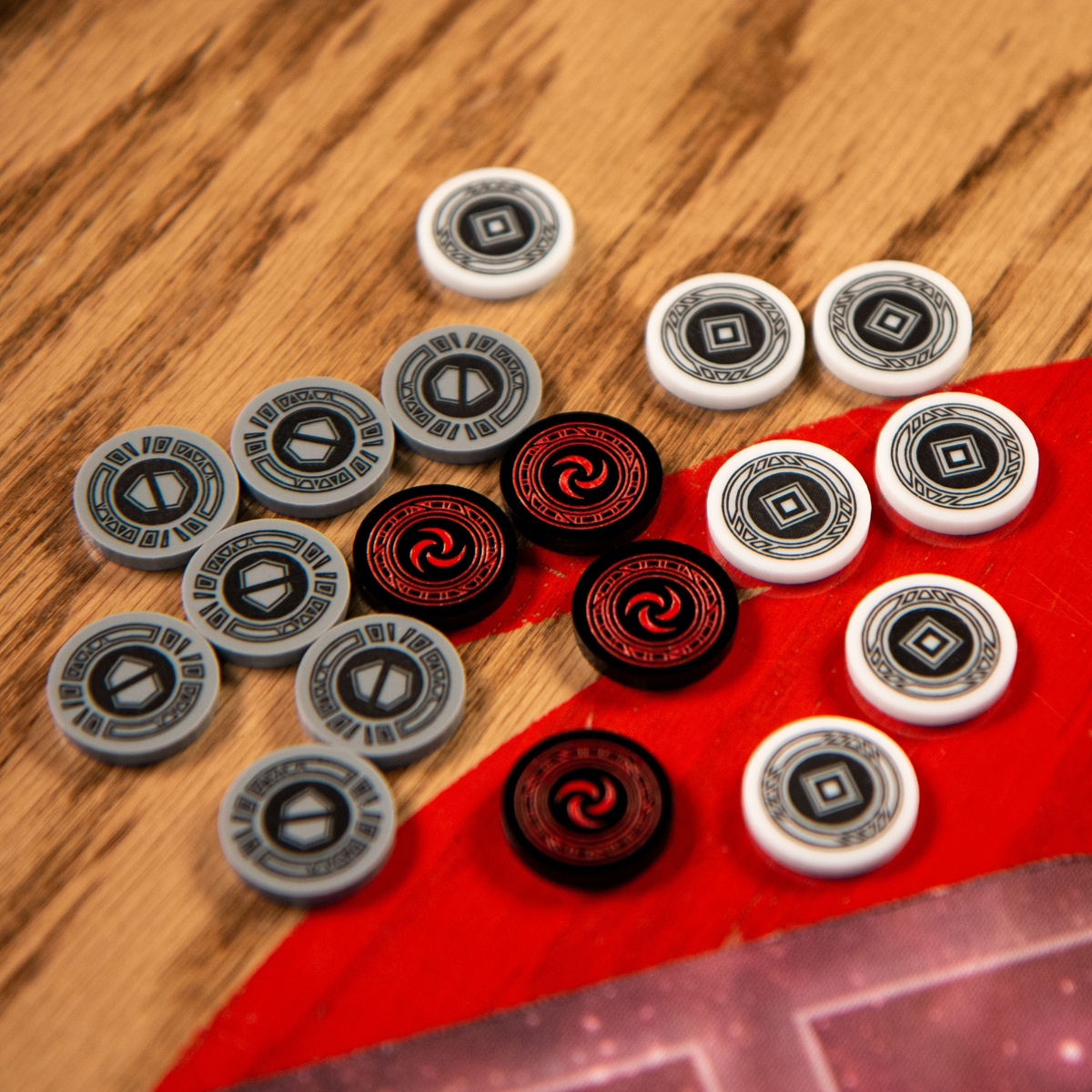Eight Armor Tokens, four Resource Tokens, and seven Activation Tokens displayed on a wooden table