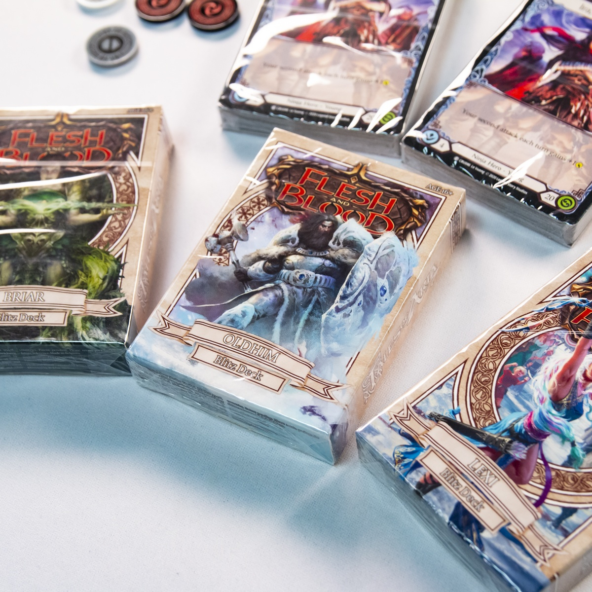 Close up of the Briar, Oldhim, and Lexi Aria Blitz Decks with two Ira Decks above. A few Majestic Tokens can be seen in the top left.
