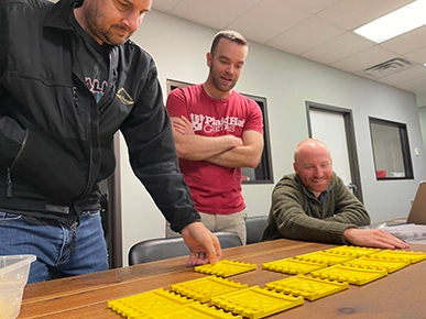 Bryce, Robert, and Steven discussing different design treatments of the Yellow Beam Cosmic Board for Marvel Champions.
