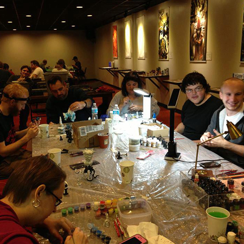 Painting miniatures at a table with Covenant employees and others.